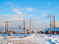 Железнодорожный переезд в солнечный морозный день на окраинах старинного русского города Гатчина.