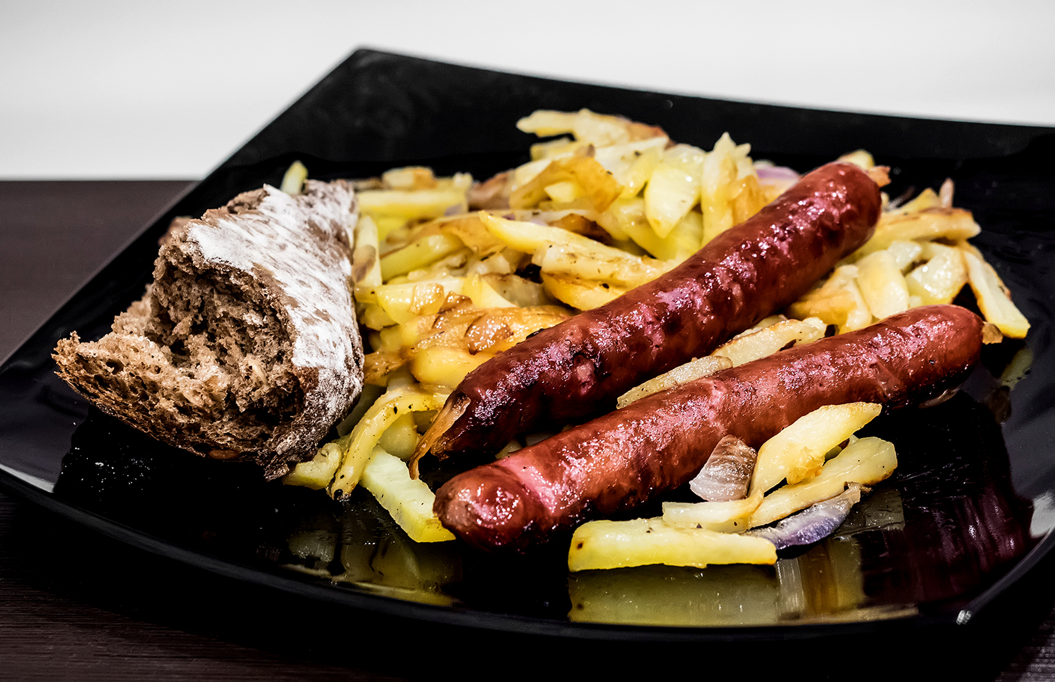 Колбаски-гриль с жареной картошкой и ржаным хлебом.