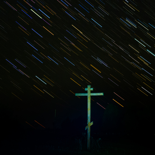 Деревянный крест на кладбище тёмной ночью
